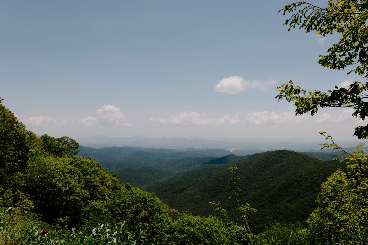 Breathtaking panorama of lush green Appalachian Mountains under a blue sky in Asheville, NC.